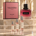 Valentino Donna Born in Roma Intense bottle and box with Alabaster Elixir 2 ml, 5 ml and 10 ml decant atomizers on a marble display.